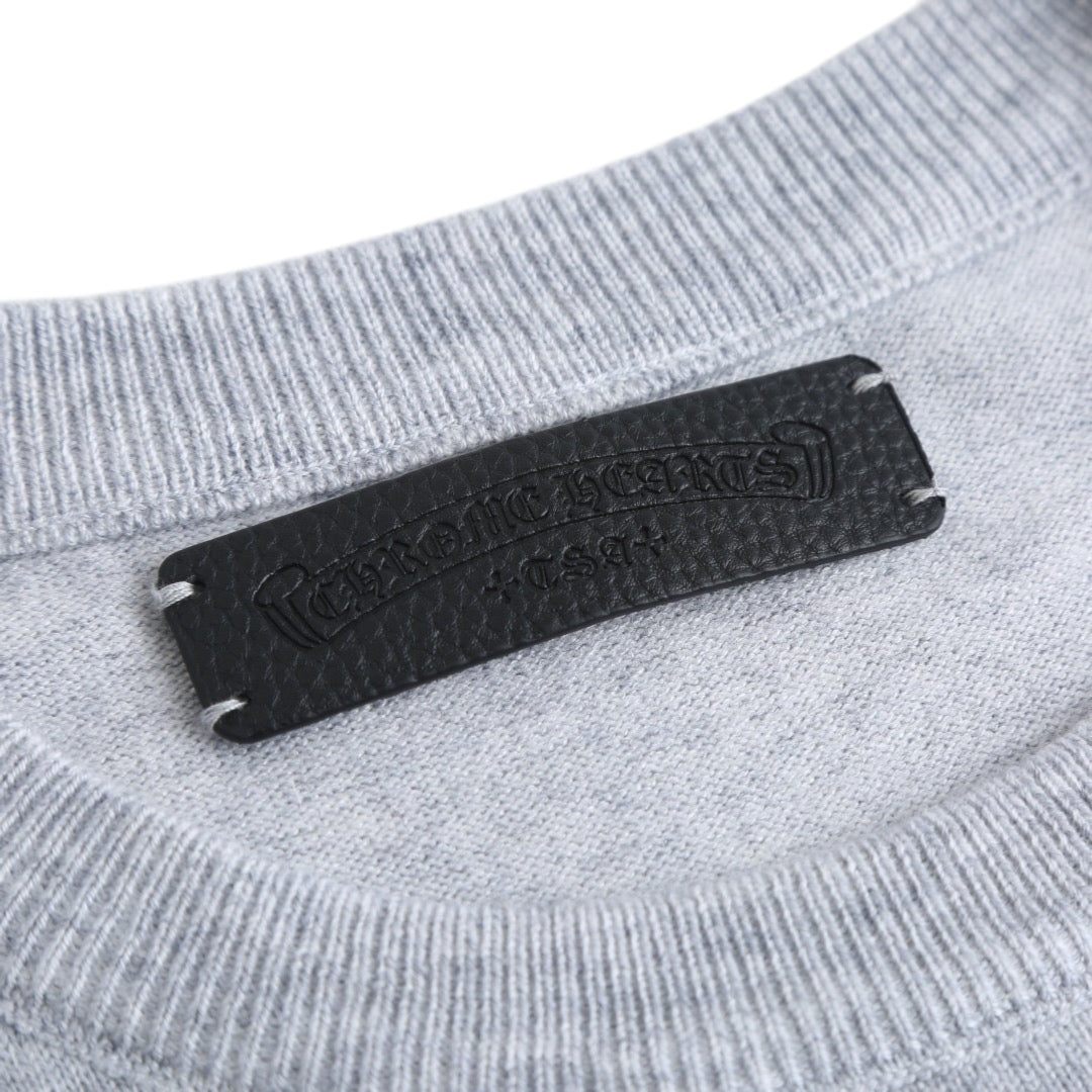 Black brand label on the neckline of a light gray crewneck sweatshirt.