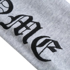 Light gray sweatshirt sleeve with black and white logo print detail.