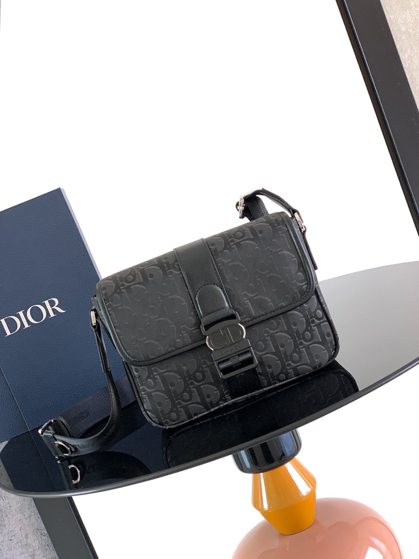 Dior bag with dark Dior Oblique canvas, front flap, and black buckle closure