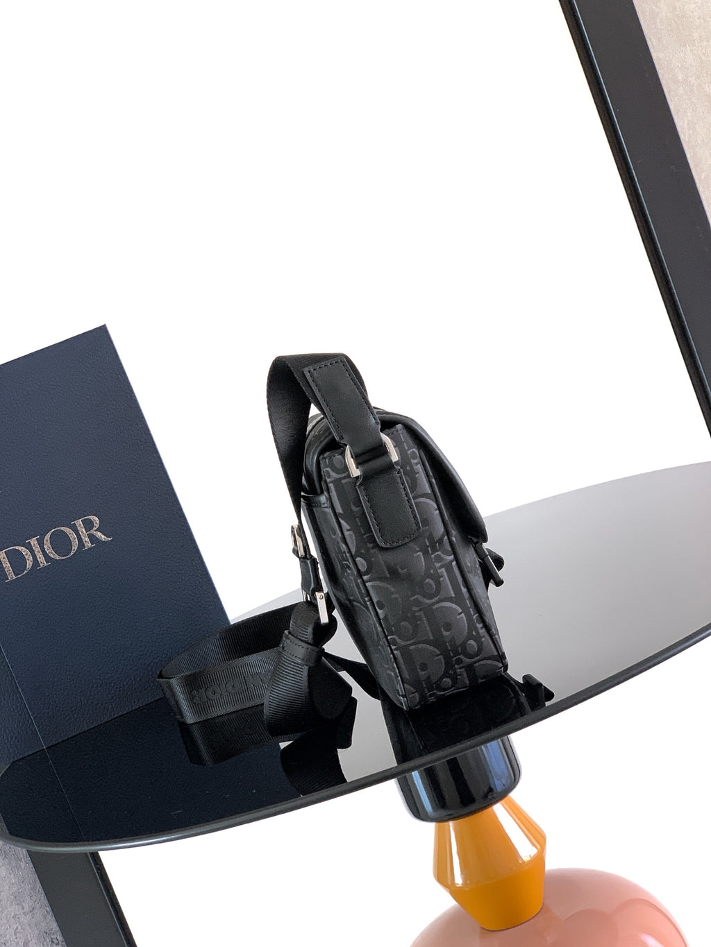 Dior bag with dark Dior Oblique canvas and black adjustable strap with metal hardware