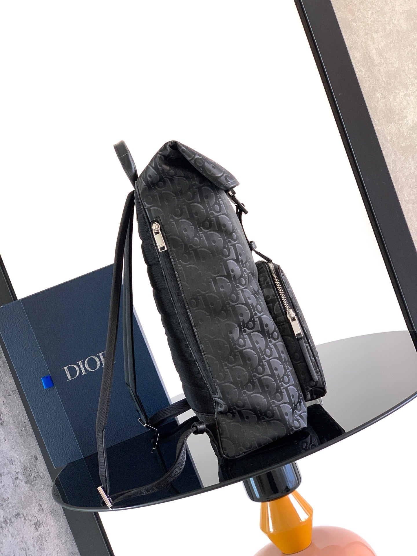 Dior black monogram backpack, side view with zipper pocket and shoulder straps