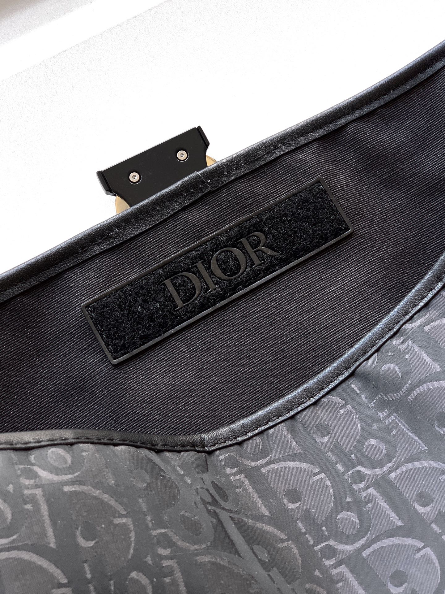 Dior bag interior with black fabric lining and Dior logo patch
