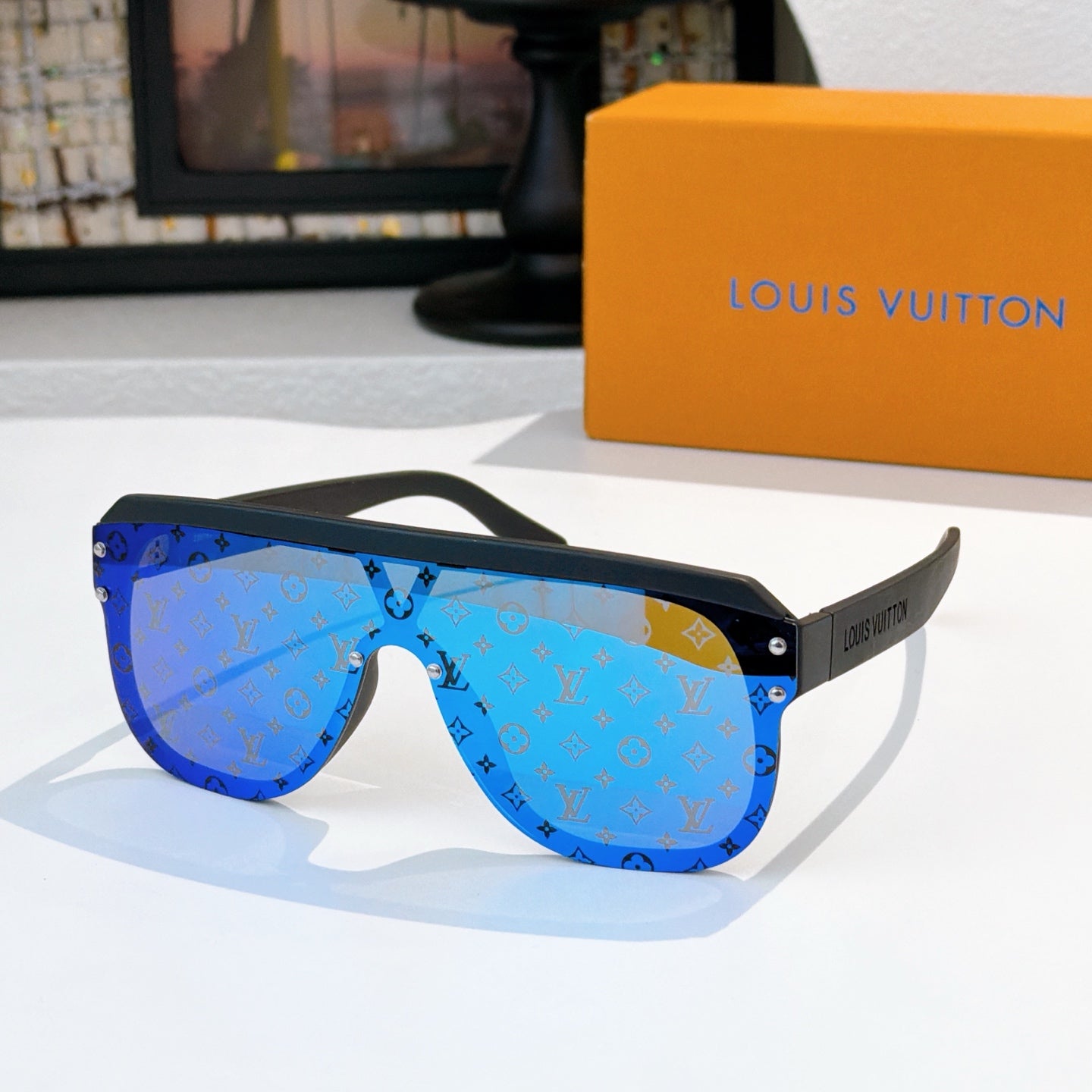 Sunglasses with bright blue allover monogram pattern and black frame