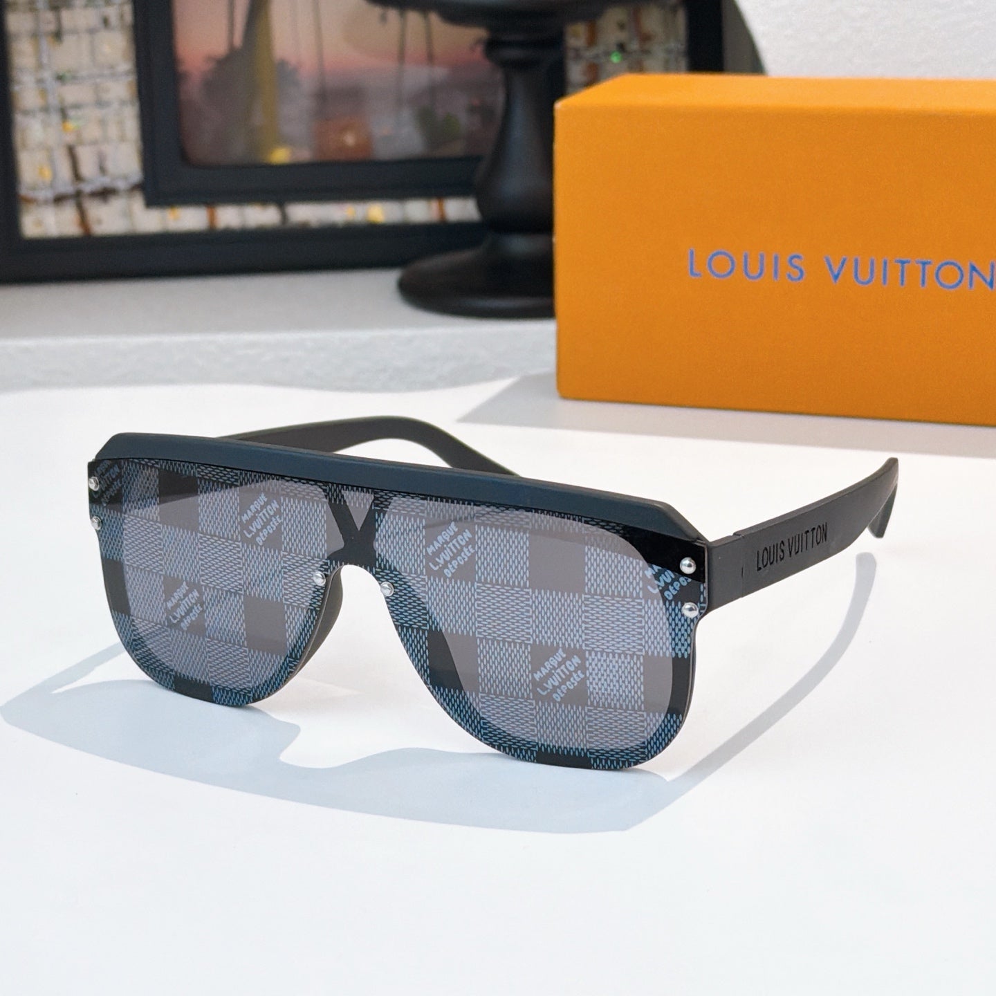 Louis Vuitton sunglasses with dark blue patterned lenses and black frame