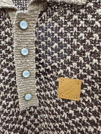 Louis Vuitton polo close-up: cream and dark knit, blue buttons and gold logo patch