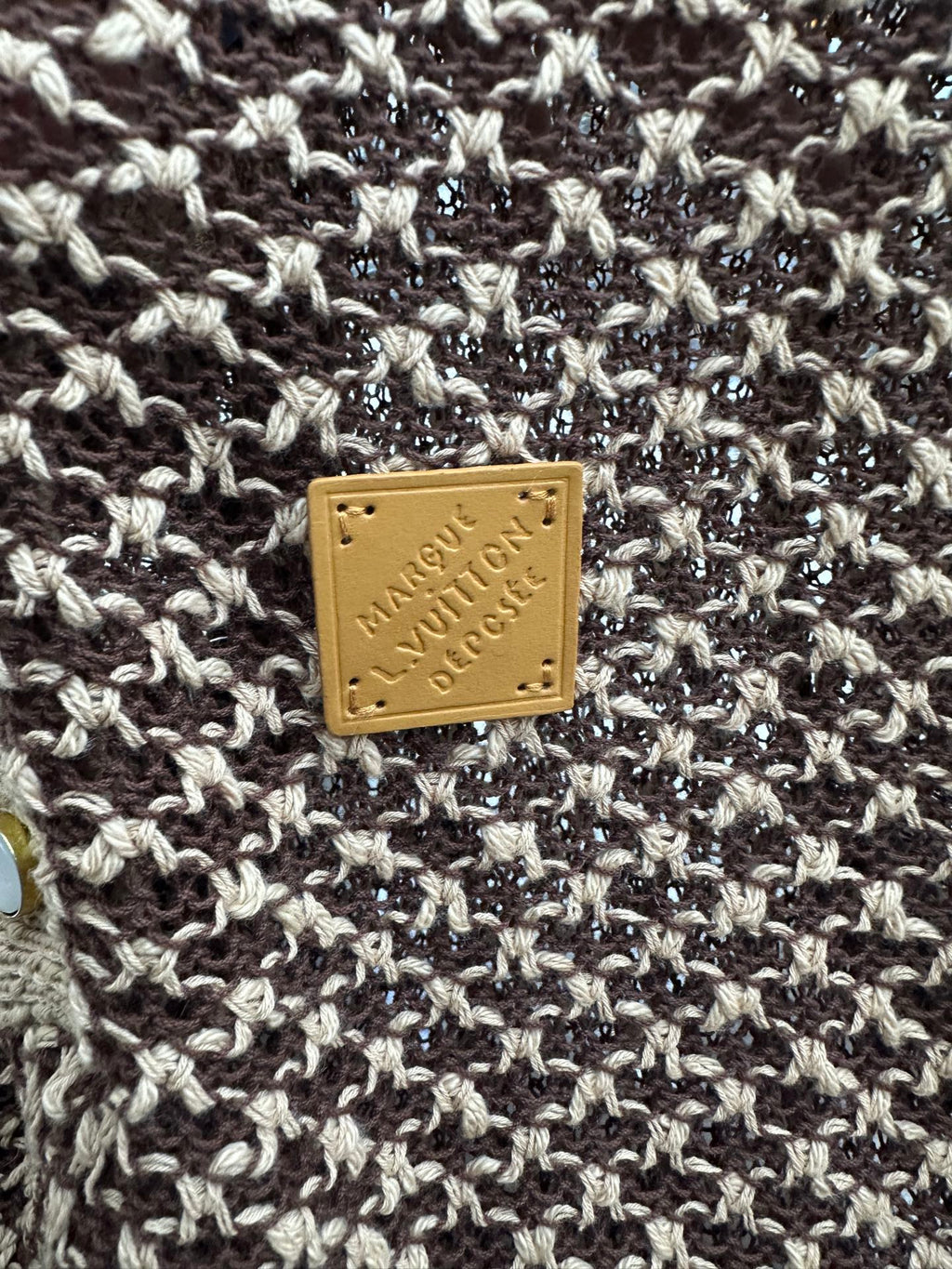 Louis Vuitton logo leather patch on knit polo fabric, gold on brown and cream