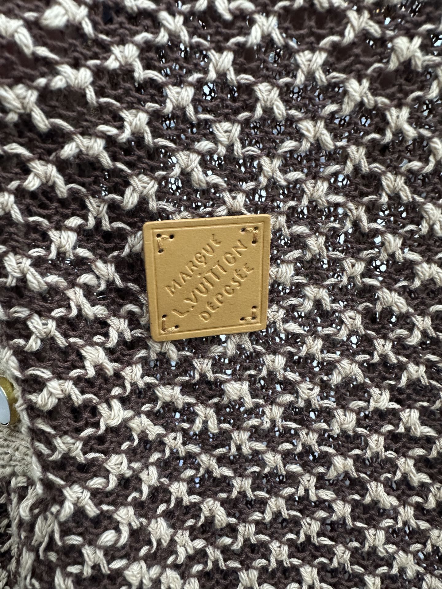 Louis Vuitton logo leather patch on knit polo fabric, gold on brown and cream