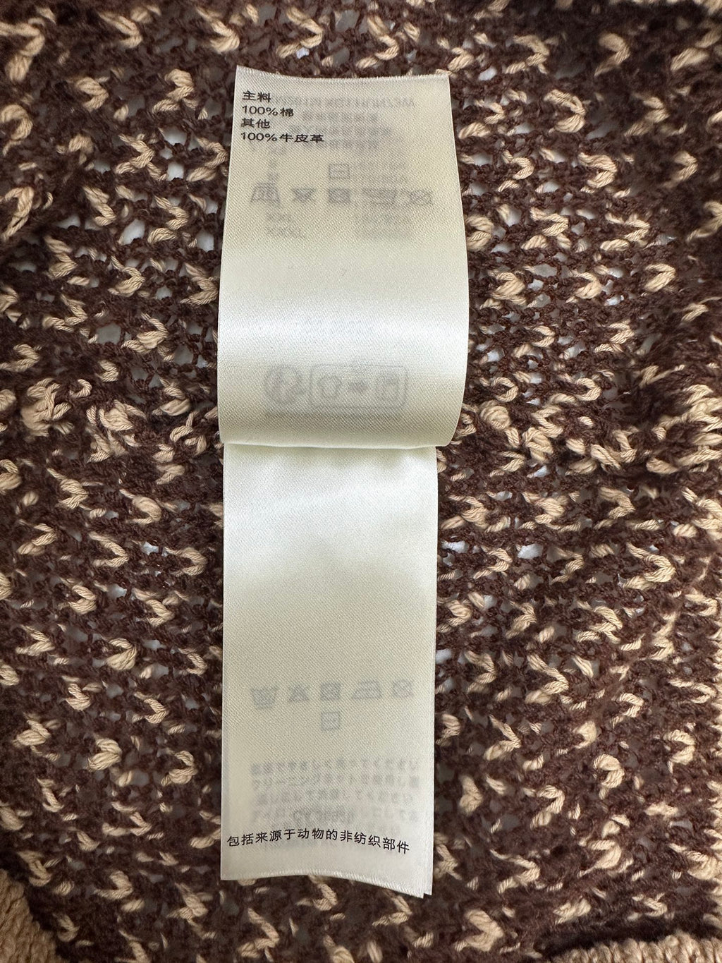 Louis Vuitton care label on knit polo fabric with wash symbols and materials info