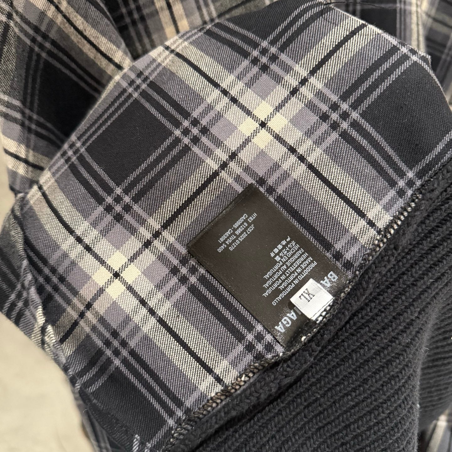 Balenciaga long-sleeve sweater care label on plaid fabric with size info