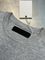 Light gray ribbed crewneck sweatshirt with collar cutout and black backing