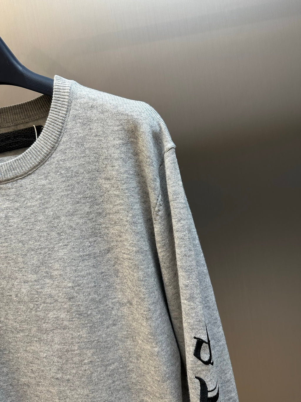 Light gray heather sweatshirt sleeve with black vertical graphic print