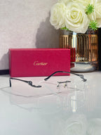 Cartier eyeglasses with clear lenses, dark frame and gold-tone decorative arms.