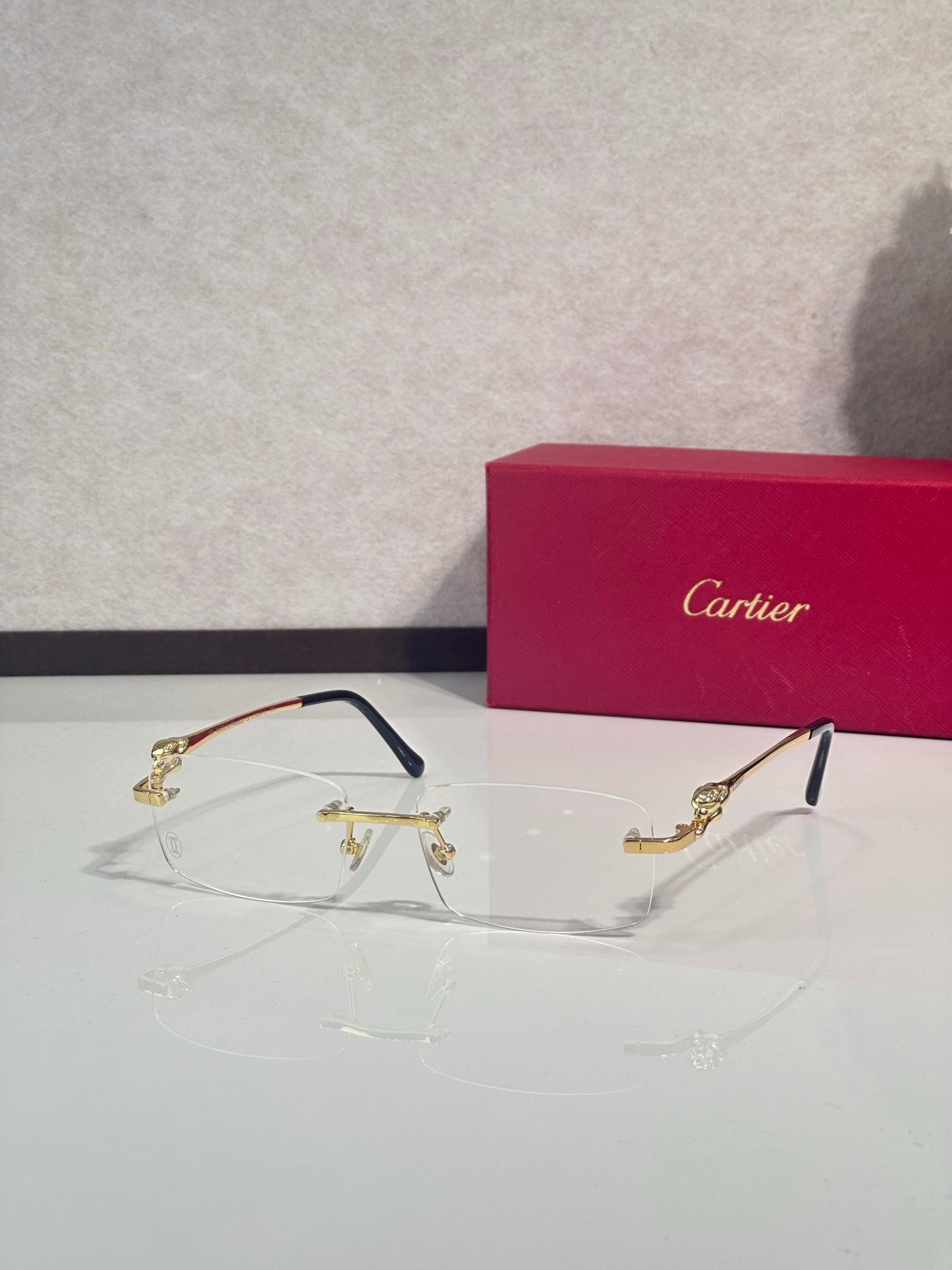 Cartier eyeglasses with clear lenses, dark frame and gold-tone hinges, front view.