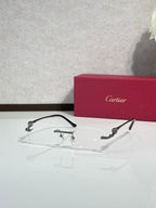 Cartier eyeglasses with clear lenses, dark frame and gold-tone accents, angled view.