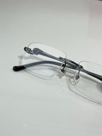 Cartier eyeglasses close-up with clear lenses, dark arms and metal bridge detail.