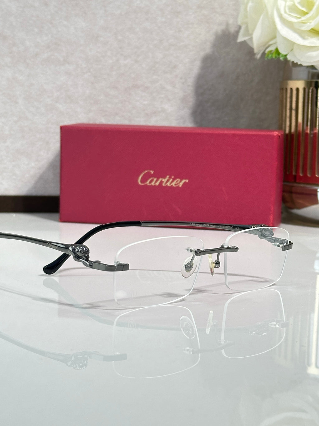 Cartier eyeglasses with clear lenses and dark frame, gold-tone temple detail, side view.
