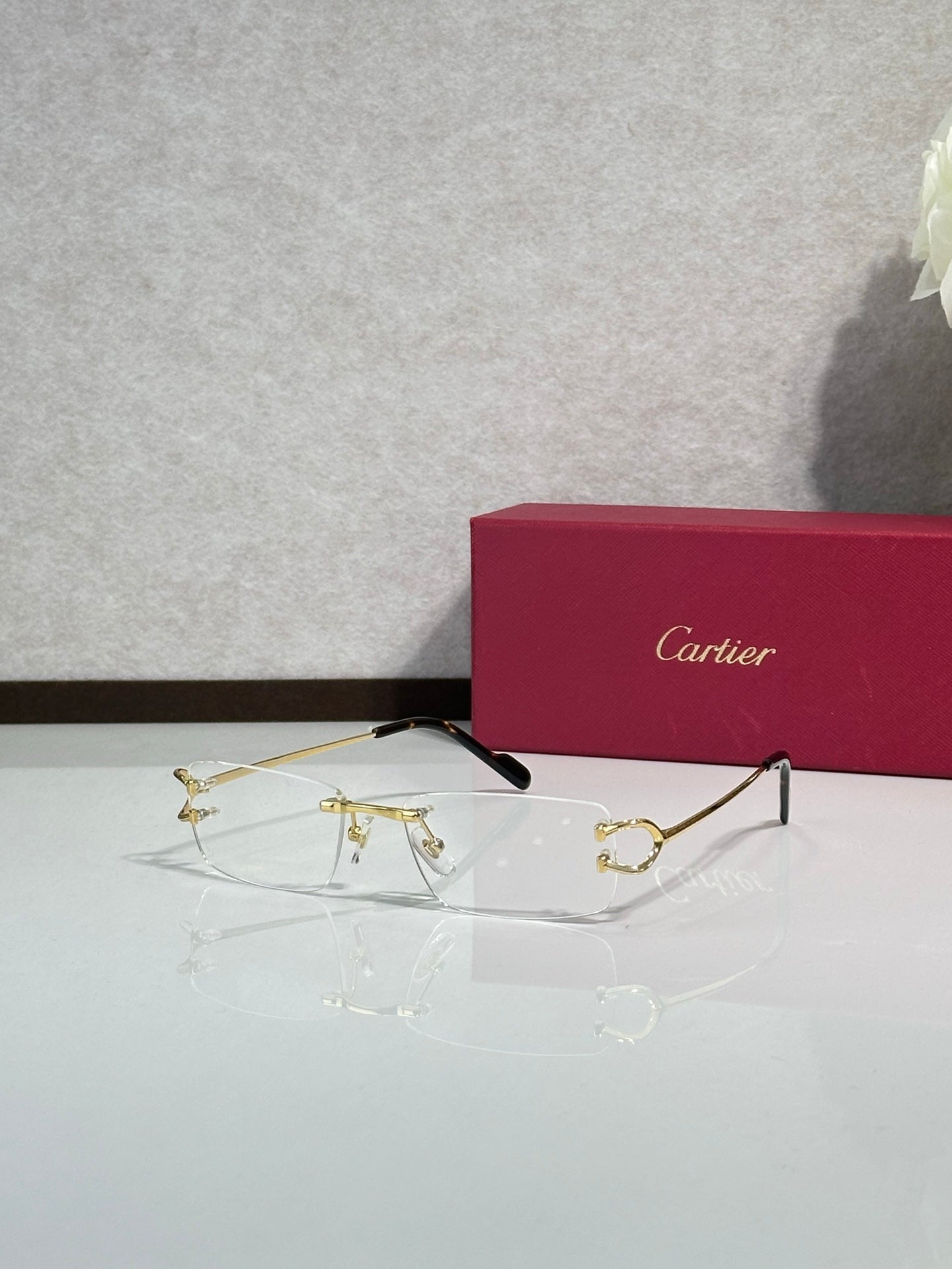Gold-tone eyeglasses with black temple tips and clear lenses