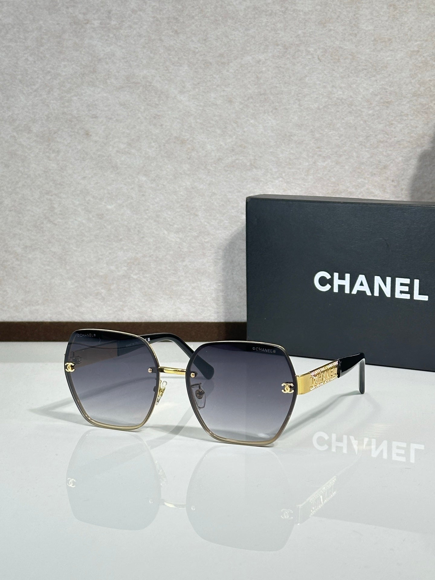 Chanel glasses with dark frames and blue gradient lenses