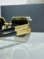 Chanel glasses close-up with gold frames and blue-green lenses
