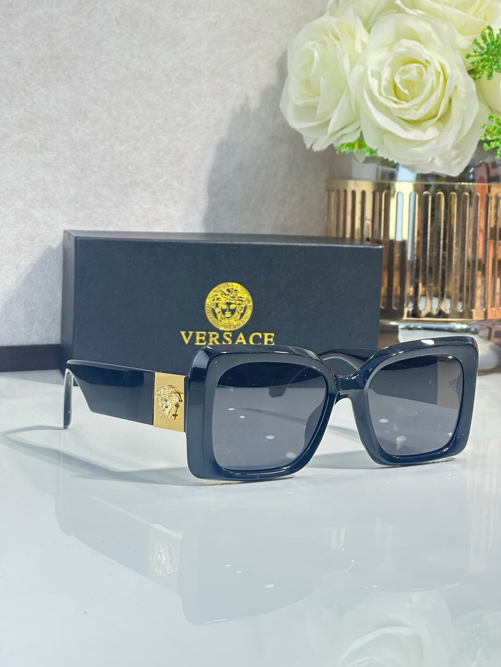 Square Versace sunglasses, dark navy frame with gray lenses.
