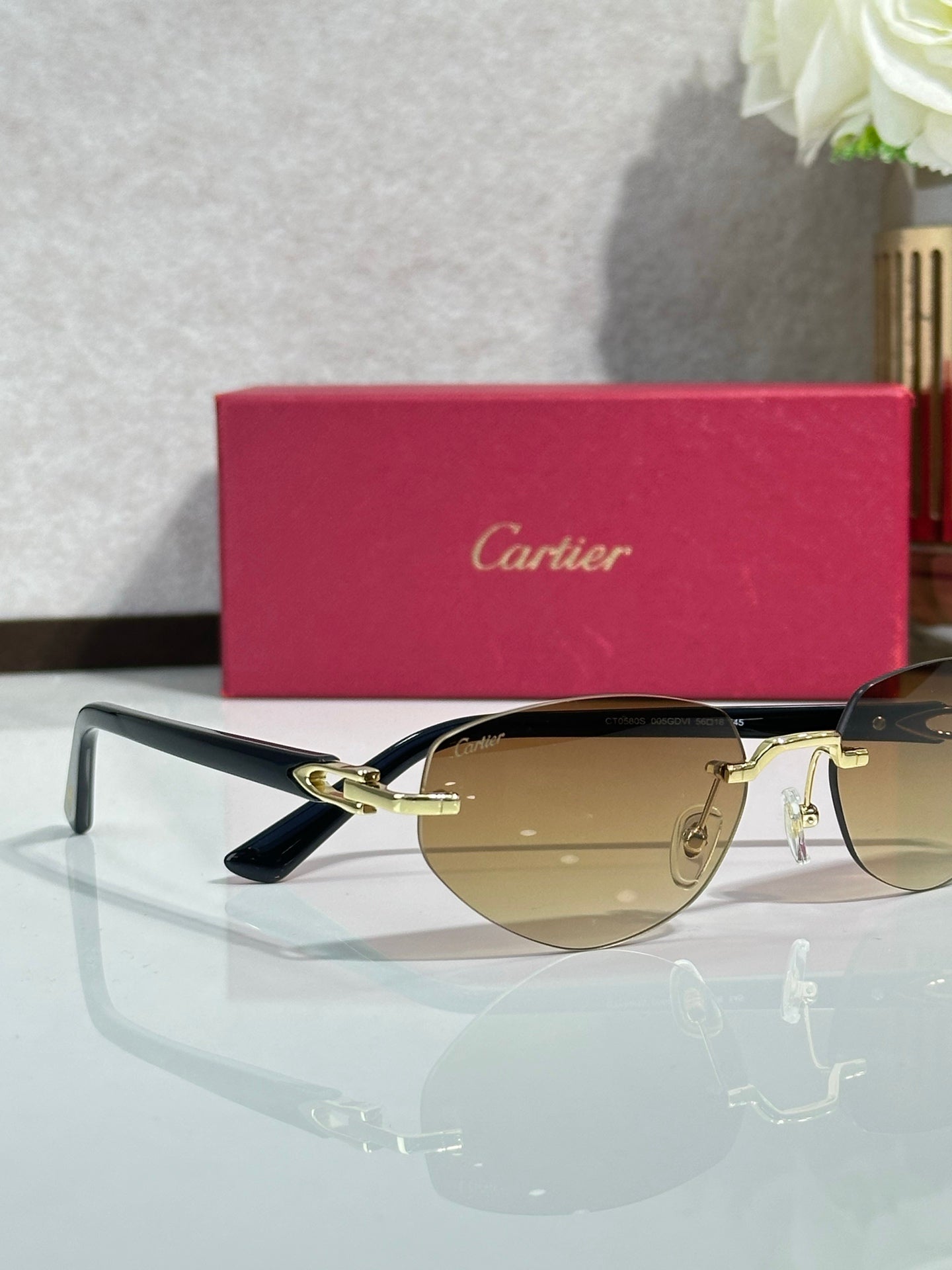 Cartier sunglasses with gold-tone rims and amber lenses, dark blue arms