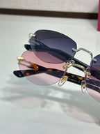 Cartier sunglasses with dark navy frame, gold details, and pink-to-blue lenses