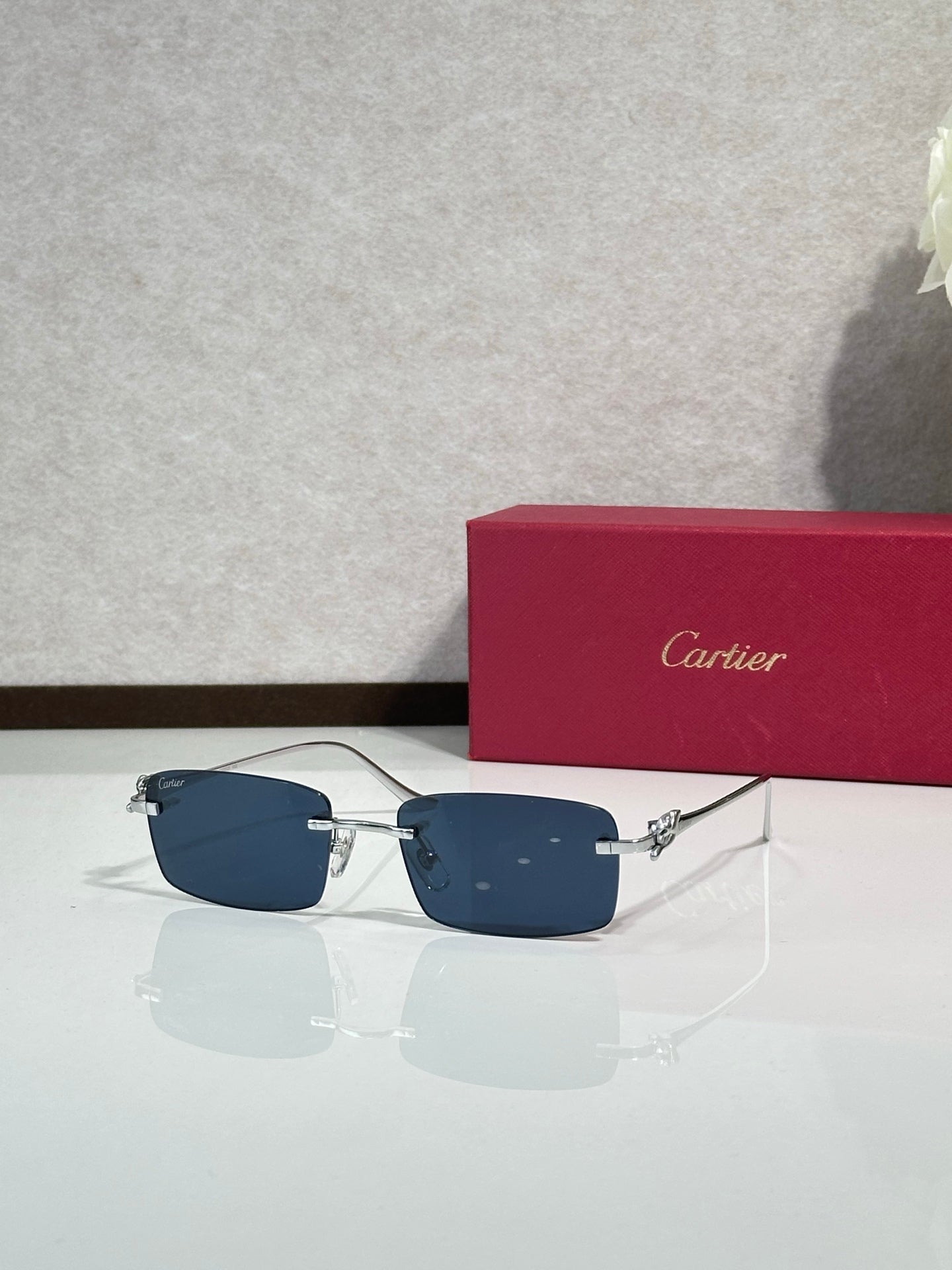 Sunglasses with blue-tinted lenses, metal frame and gold-tone temple accents