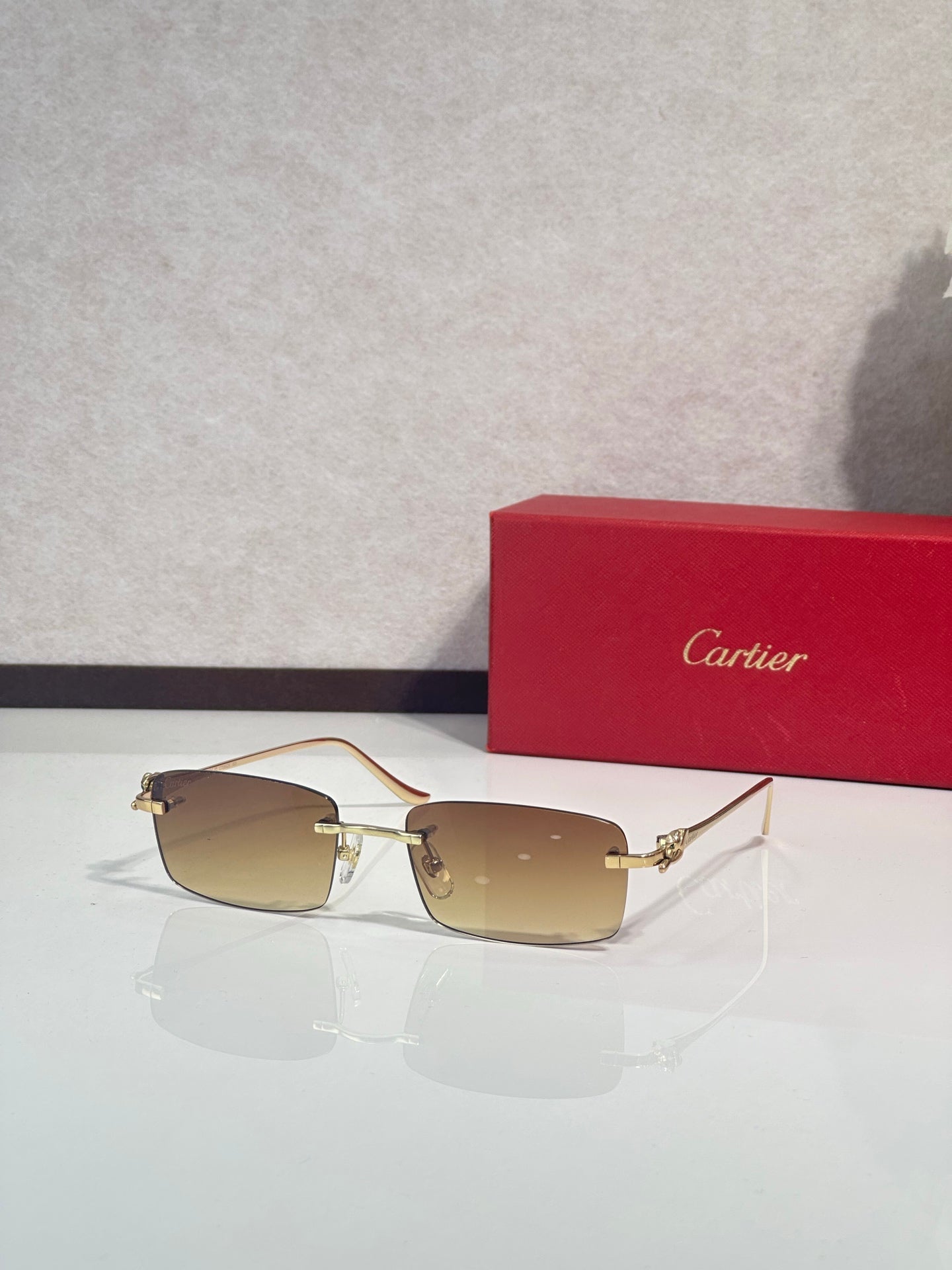 Sunglasses with brown-tinted lenses, metal frame and gold-tone temple hardware