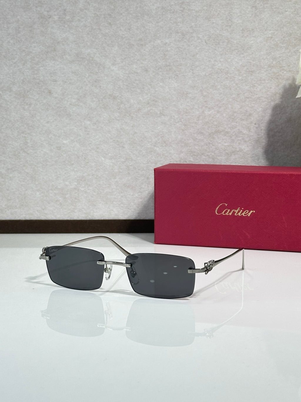 Sunglasses with dark gray lenses, metal frame and gold-tone temple accents