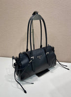 Prada handbag in dark blue leather with top handles, crossbody strap, and logo