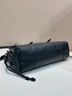 Prada handbag in dark blue leather with long shoulder strap and rolled top silhouette