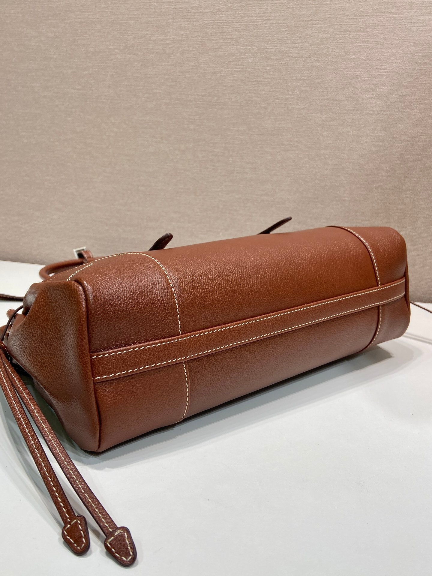 Prada brown leather tote bag with stitched paneling and thin strap loops