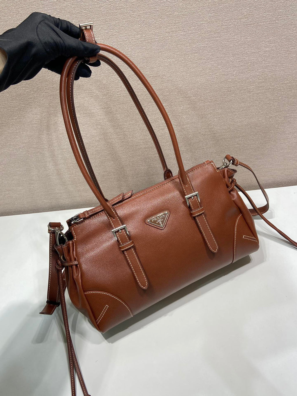 Prada brown leather tote bag detail with top handles and side tassel pulls