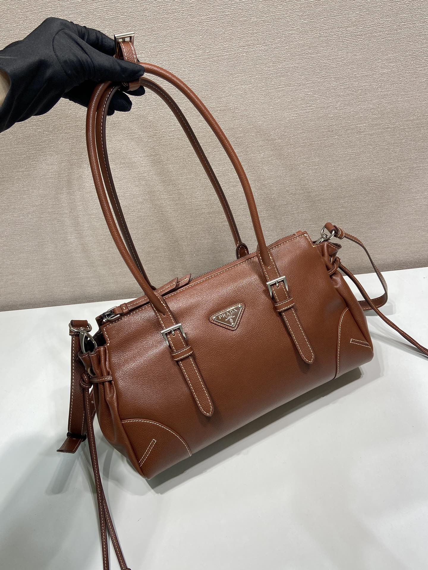 Prada brown leather tote bag detail with top handles and side tassel pulls