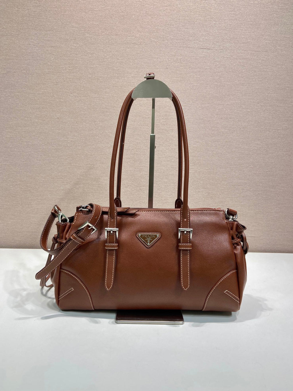 Prada brown leather tote bag with top handles, logo triangle, and silver hardware