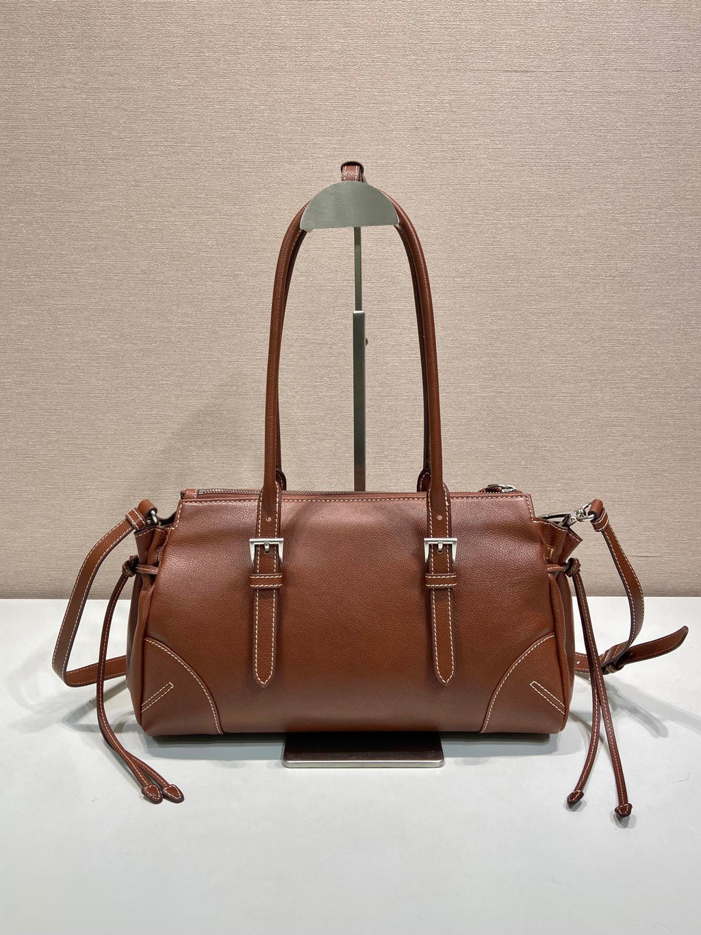 Prada brown leather tote bag with two top handles and side drawstring ties