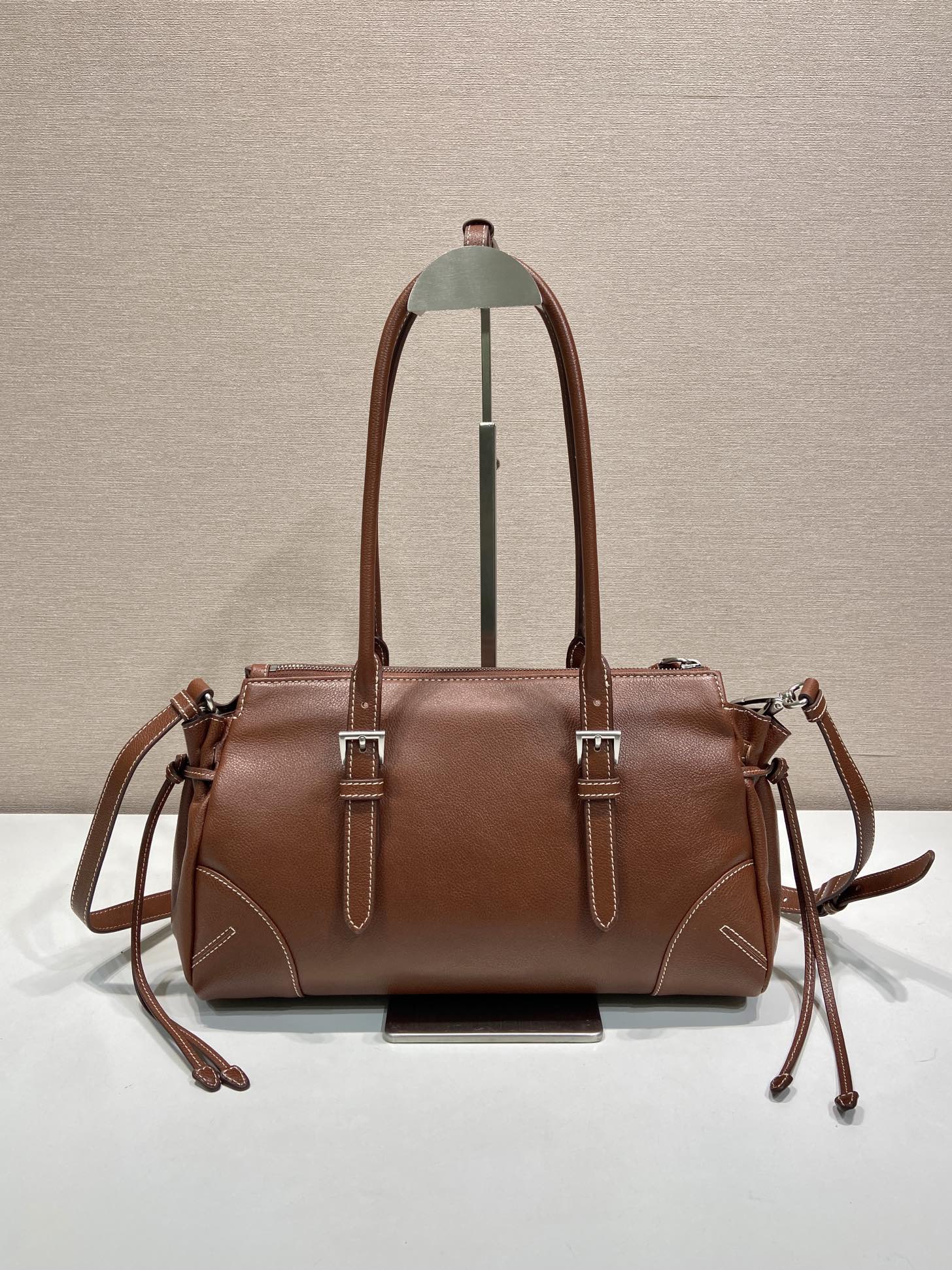 Prada brown leather tote bag with two top handles and side drawstring ties