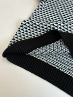 Houndstooth sweater hem detail, black ribbed trim with cream/blue check knit