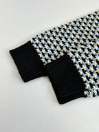 Ribbed cuffs and hem of houndstooth sweater, black knit with cream/blue grid