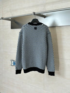 Houndstooth knit sweater on hanger, crewneck, black with cream/blue pattern, ribbed hem