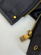 Long puffer jacket gold zipper close-up with buttoned cuff