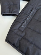 Dark navy puffer jacket sleeve detail with Louis Vuitton printed strap