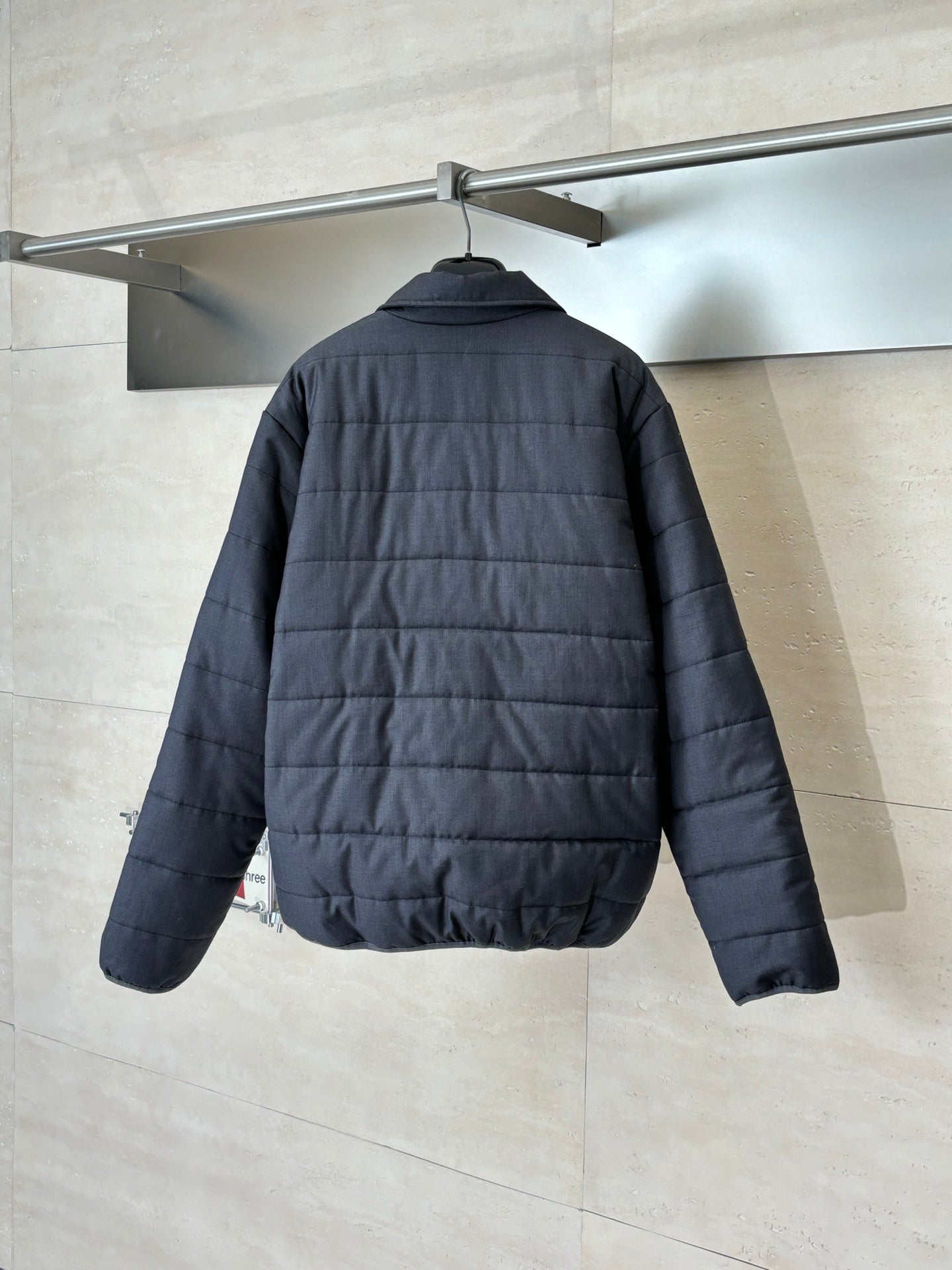 Dark navy long puffer jacket back view with quilted panels