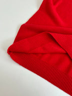 Red knit sweater with ribbed fold at shoulder and sleeve hem