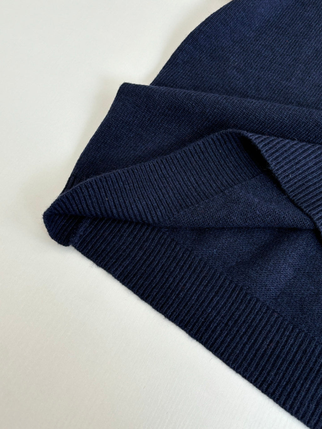 Navy ribbed knit sleeve cuff with folded hem detail