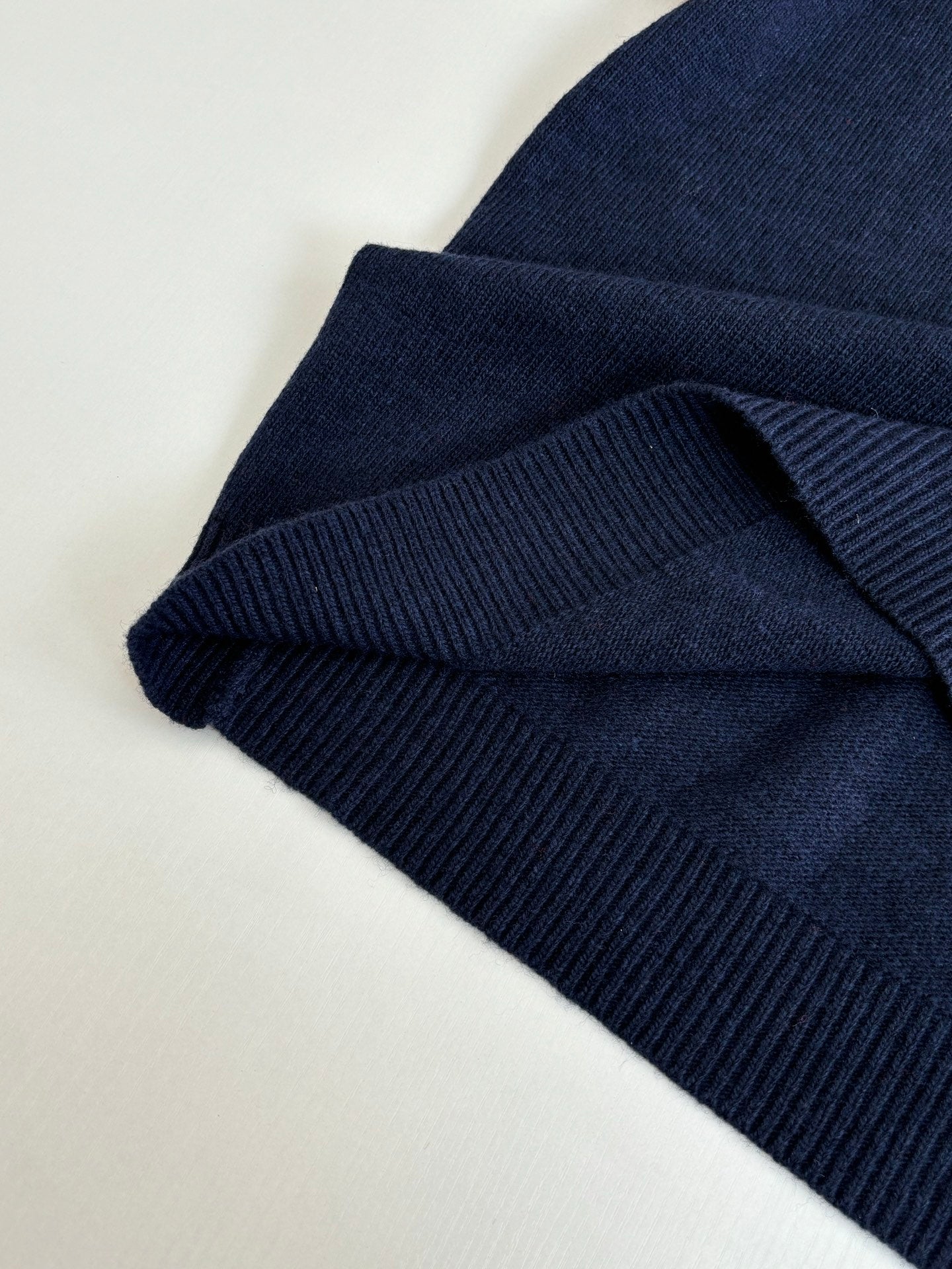 Navy ribbed knit sleeve cuff with folded hem detail