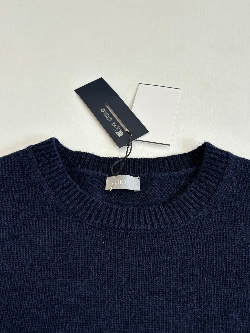 Navy crewneck knit sweater with Dior-branded tag at collar