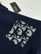 Navy knit sweater with large logo graphic patch on sleeve cuff