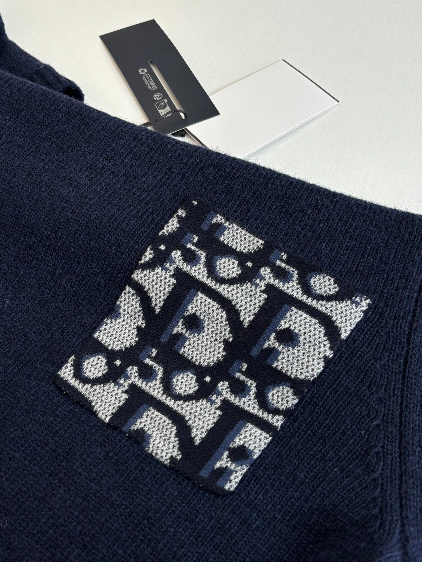 Navy knit sweater with large logo graphic patch on sleeve cuff