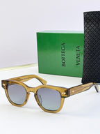 Sunglasses with gold-tone frames and textured gold temples, tinted lenses